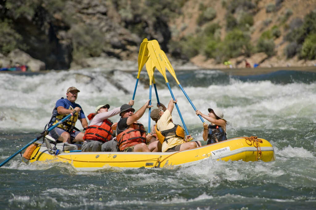 Challis, ID, USA - July, 2 2009: Rafters do a paddle "hi-five" after successfully running Tappen Falls, Middle Fork Salmon River, Salmon-Challis National Forest, central Idaho.