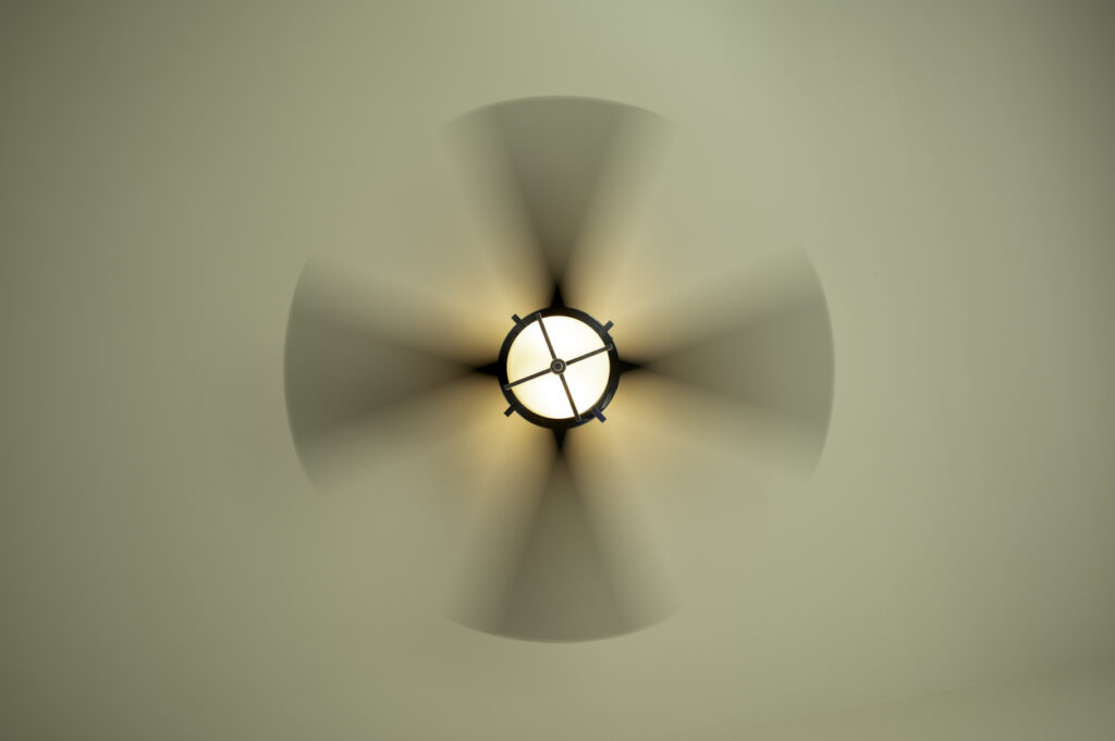 Looking up a modern ceiling fan spinning in motion