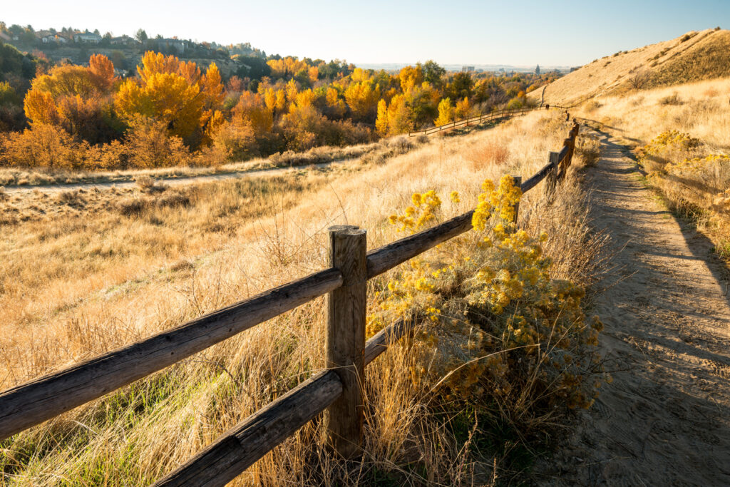 Wood rail fence leads along a path in the fall in Boise's foothills
