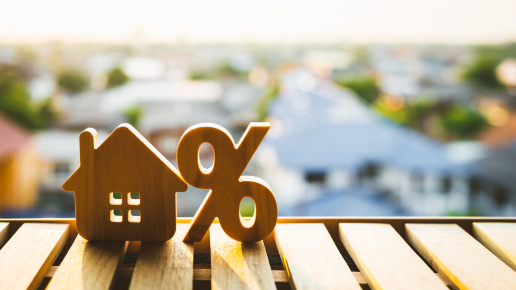 Percentage and house sign symbol icon wooden on wood table. Concepts of home interest, real estate, investing in inflation.